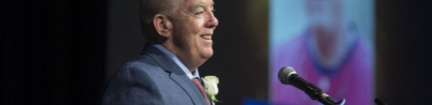 Photo of FAU baseball coach on stage by podium