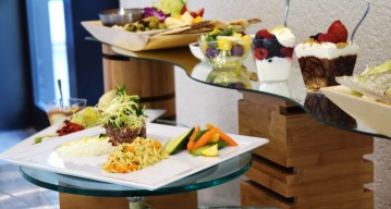 Photo of several assorted plates of hors d’oeuvres set on wooden platforms